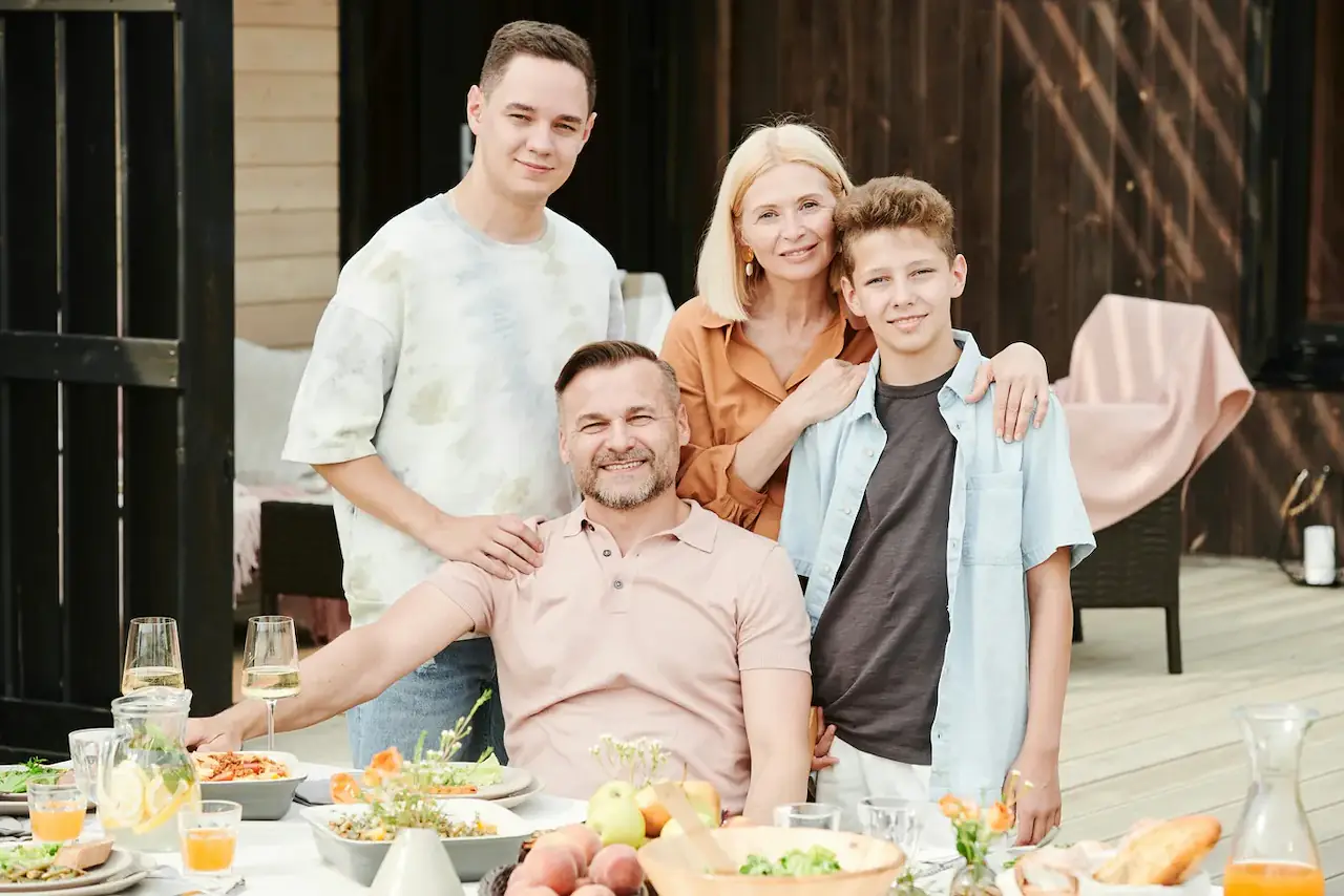 A host family gathered around a young guest on a terrace